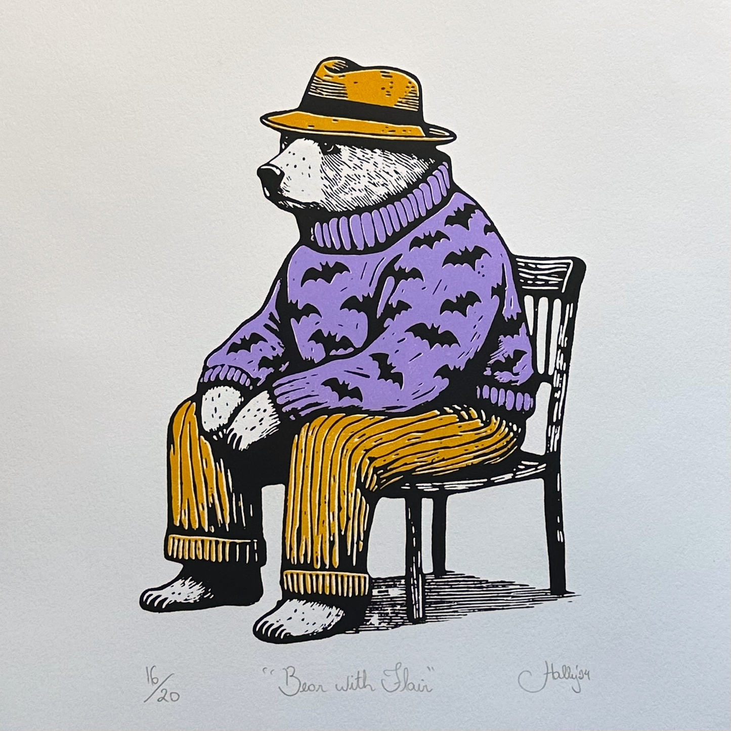 A bear with serious sartorial flair, reclining on a wooden chair, this sophisticate bear sits wearing a vibrant yellow trilby hat with matching trousers and a jumper emblazoned with bats. This is a great gift for bear lovers who like something spooky too. 